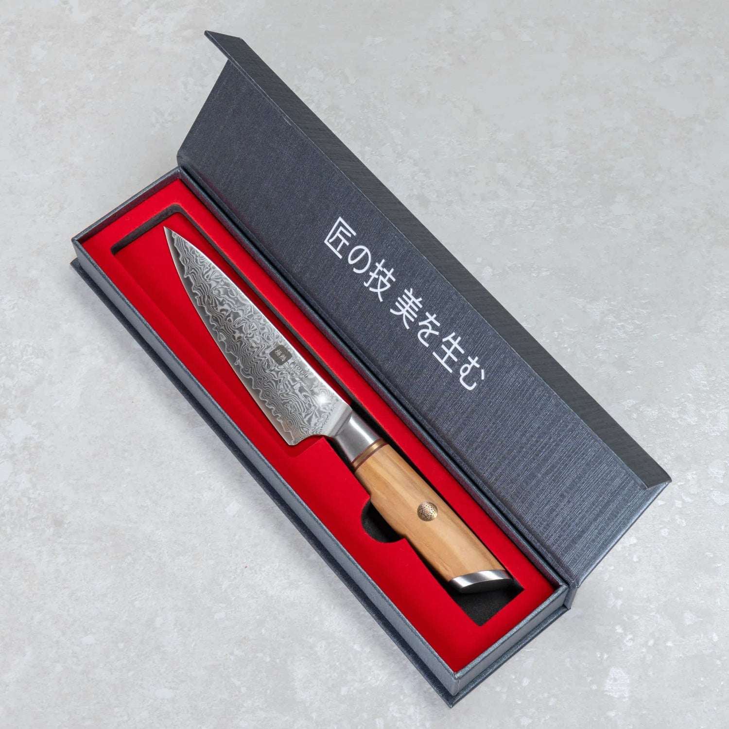 Kyotsu Allzweckmesser aus Damaststahl in geöffneter Verpackung.