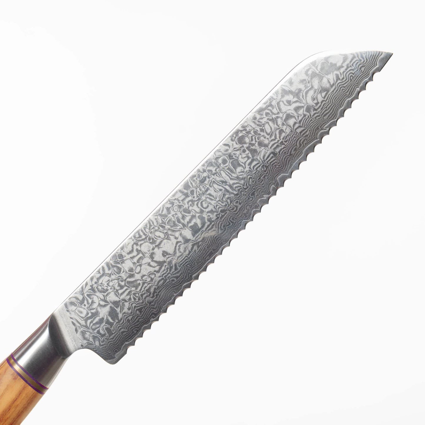 Nahaufnahme der Klinge aus Damaststahl. Die wunderschöne Maserung aufgrund der Stahlschichten ist klar erkennbar.
