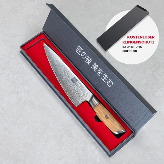 Kyotsu Chefmesser aus Damaststahl in geöffneter Verpackung.
