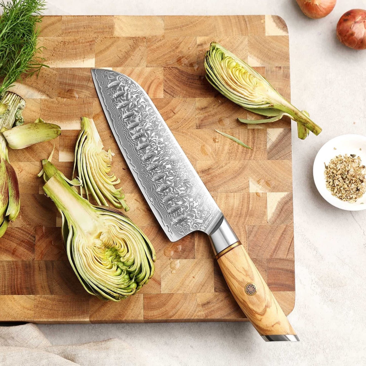 Kyotsu Santoku-Messer aus Damaststahl auf Holz-Schneidebrett mit frischen Zutaten – stilvolle Produktpräsentation für hochwertige Küchenmesser.