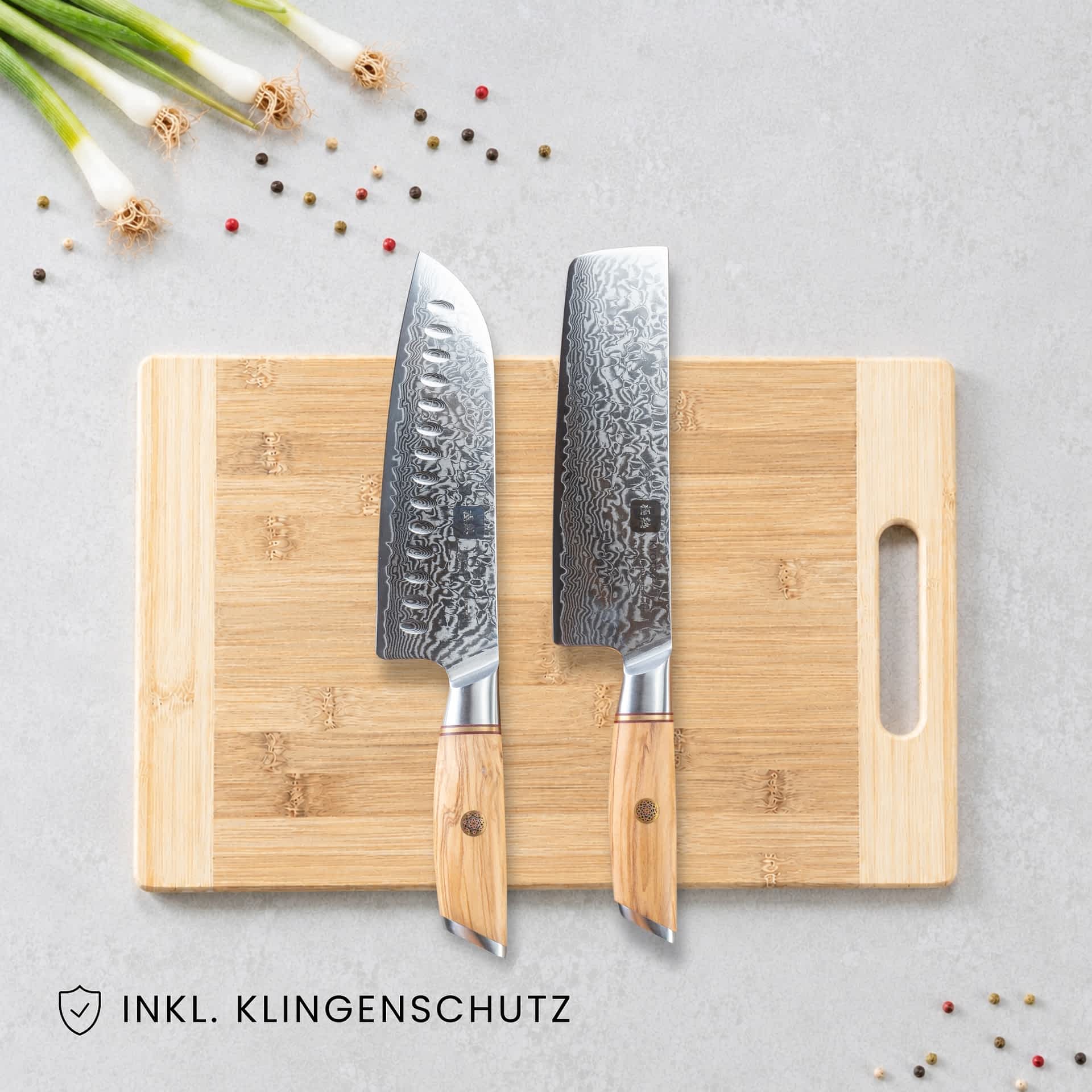 Kyotsu 2er-Set: Santoku-Messer und Nakiri-Messer liegen auf einem Holz-Schneidebrett, daneben frische Zutaten.