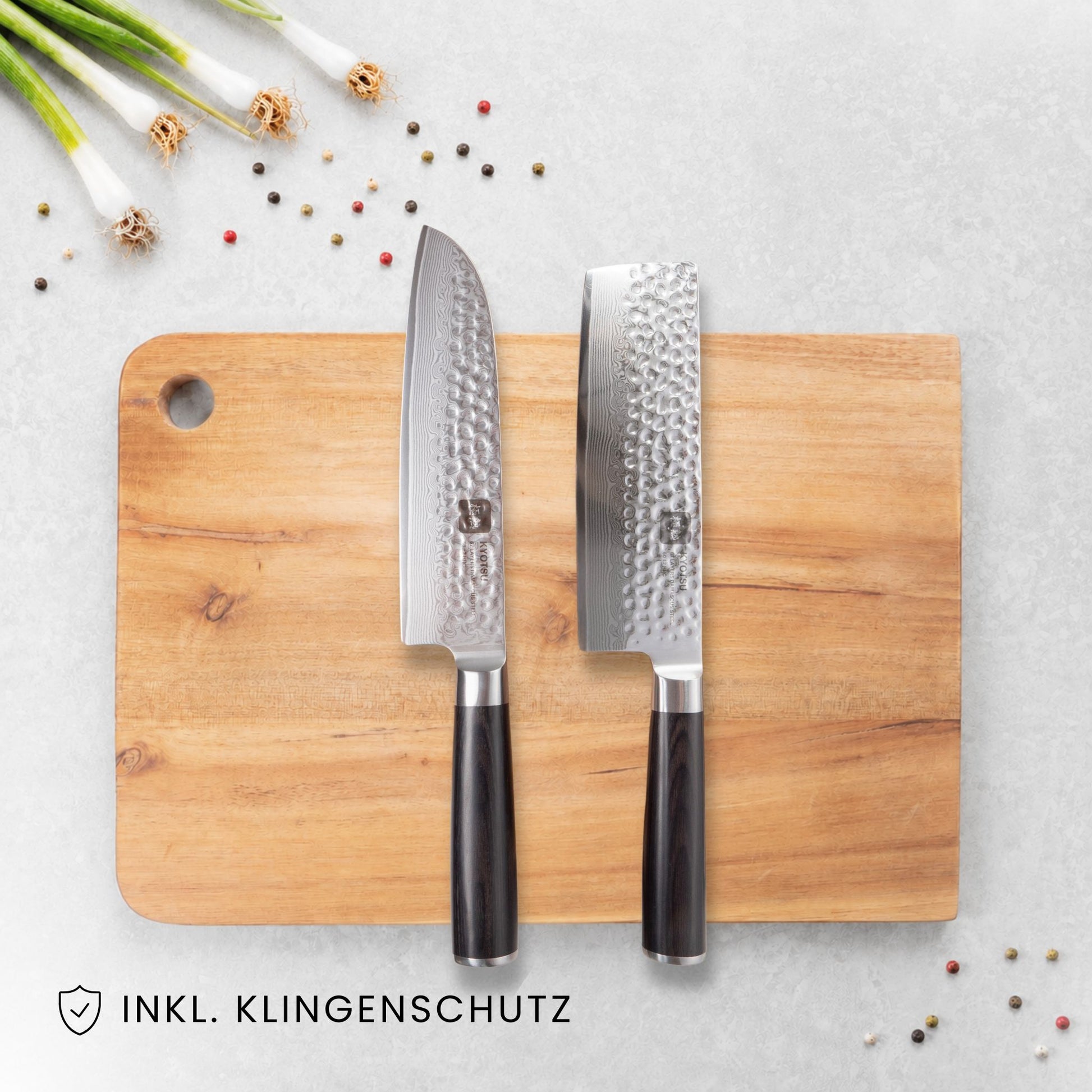 Kyotsu 2er-Set Pakka: Santoku-Messer und Nakiri-Messer liegen auf einem Holz-Schneidebrett, daneben frische Zutaten.