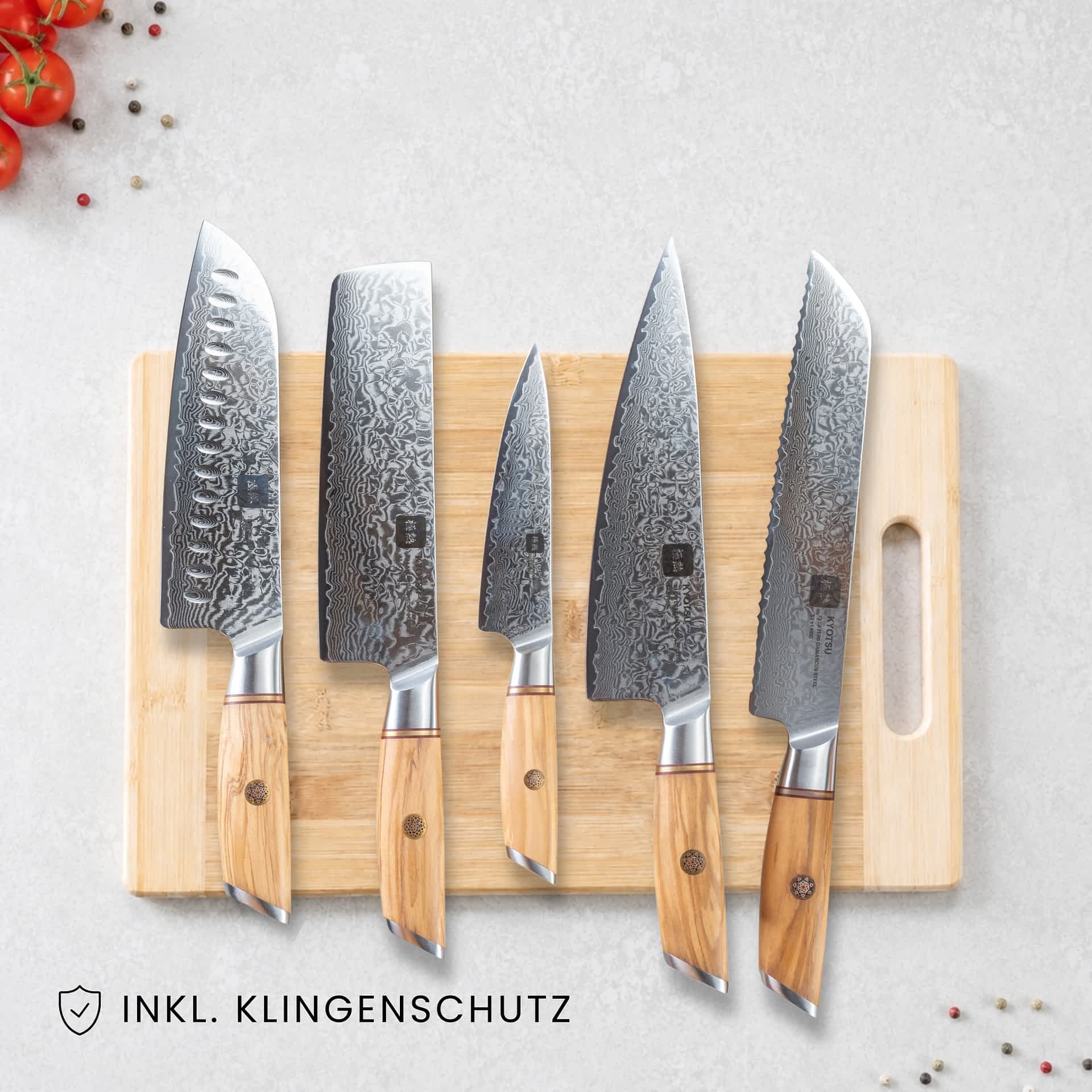 Kyotsu 5er-Set: Santoku-Messer, Nakiri-Messer, Allzweckmesser, Chefmesser und Brotmesser liegen auf einem Holz-Schneidebrett, daneben frische Zutaten.