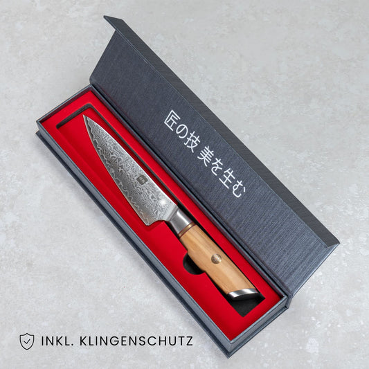 Kyotsu Allzweckmesser aus Damaststahl in geöffneter Verpackung, unten Links der Schriftzug "Inkl. Klingenschutz".