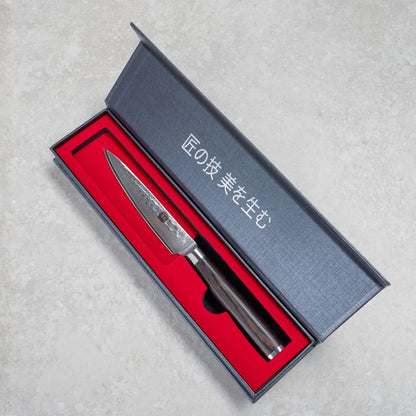 Kyotsu Allzweckmesser aus Damaststahl in geöffneter Verpackung.