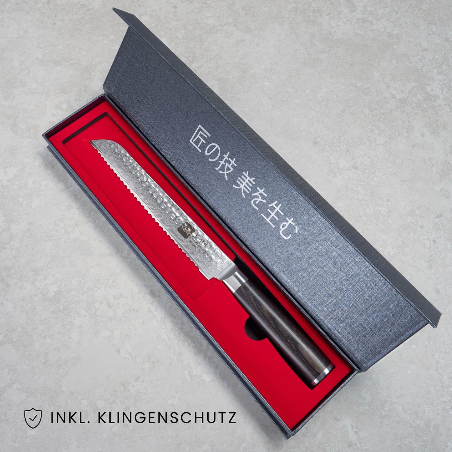 Kyotsu Brotmesser aus Damaststahl in geöffneter Verpackung, unten Links der Schriftzug "Inkl. Klingenschutz".