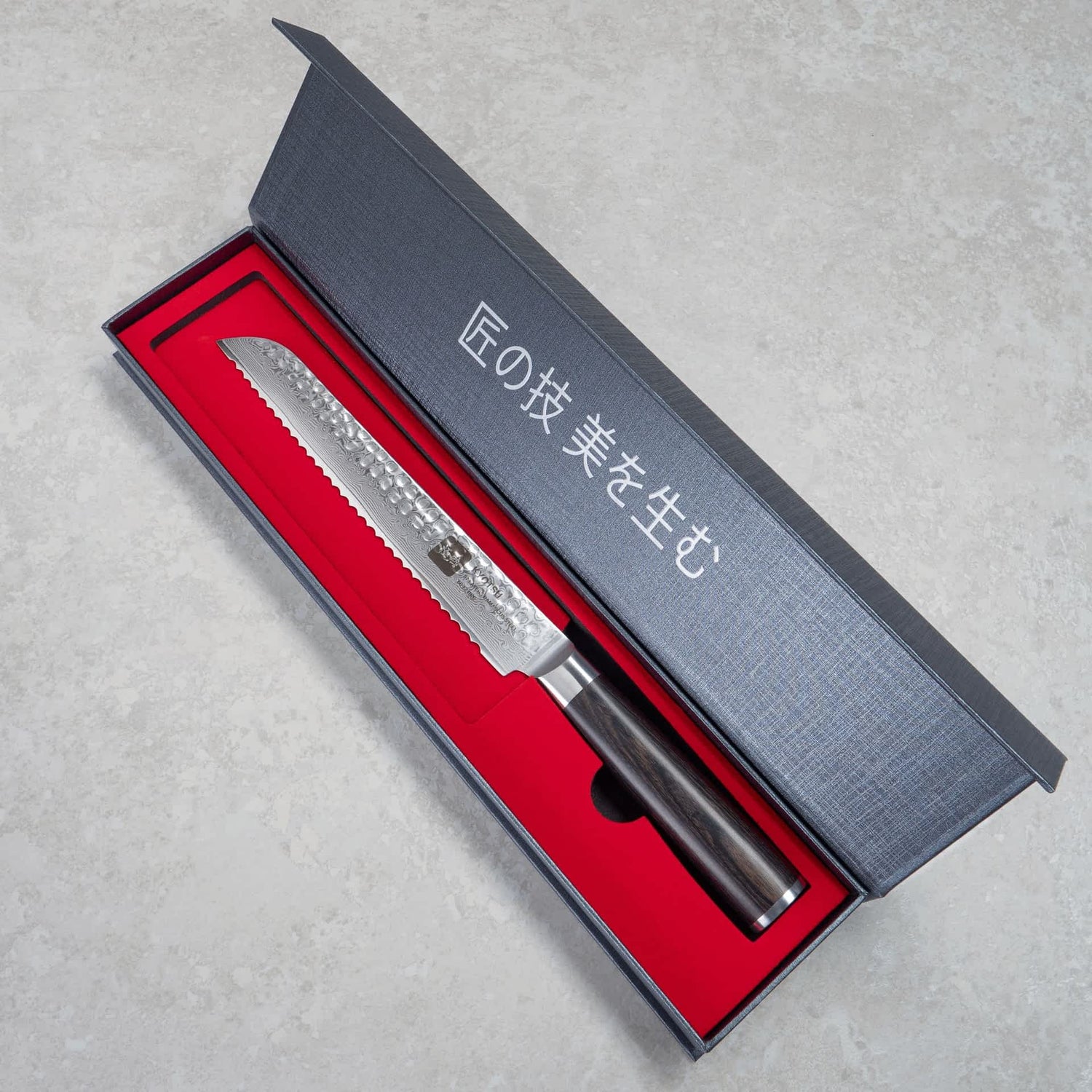 Kyotsu Brotmesser aus Damaststahl in geöffneter Verpackung.