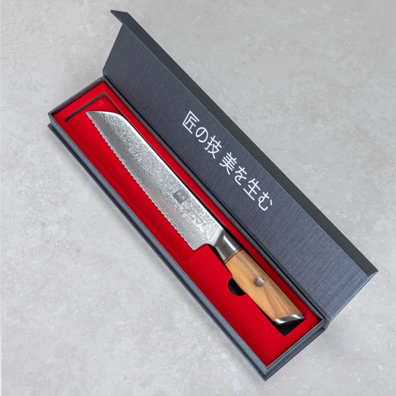 Kyotsu Brotmesser aus Damaststahl in geöffneter Verpackung.