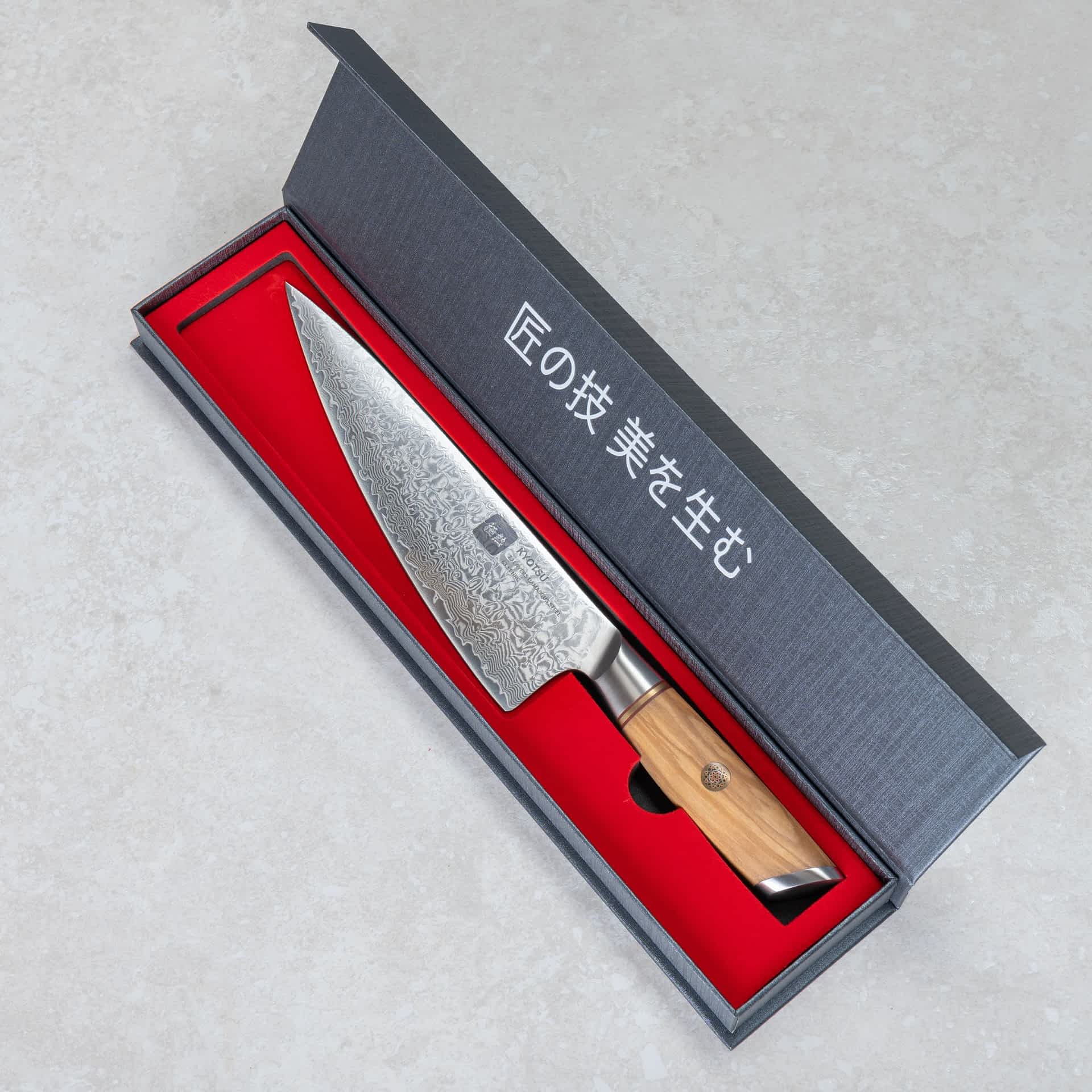 Kyotsu Chefmesser aus Damaststahl in geöffneter Verpackung.