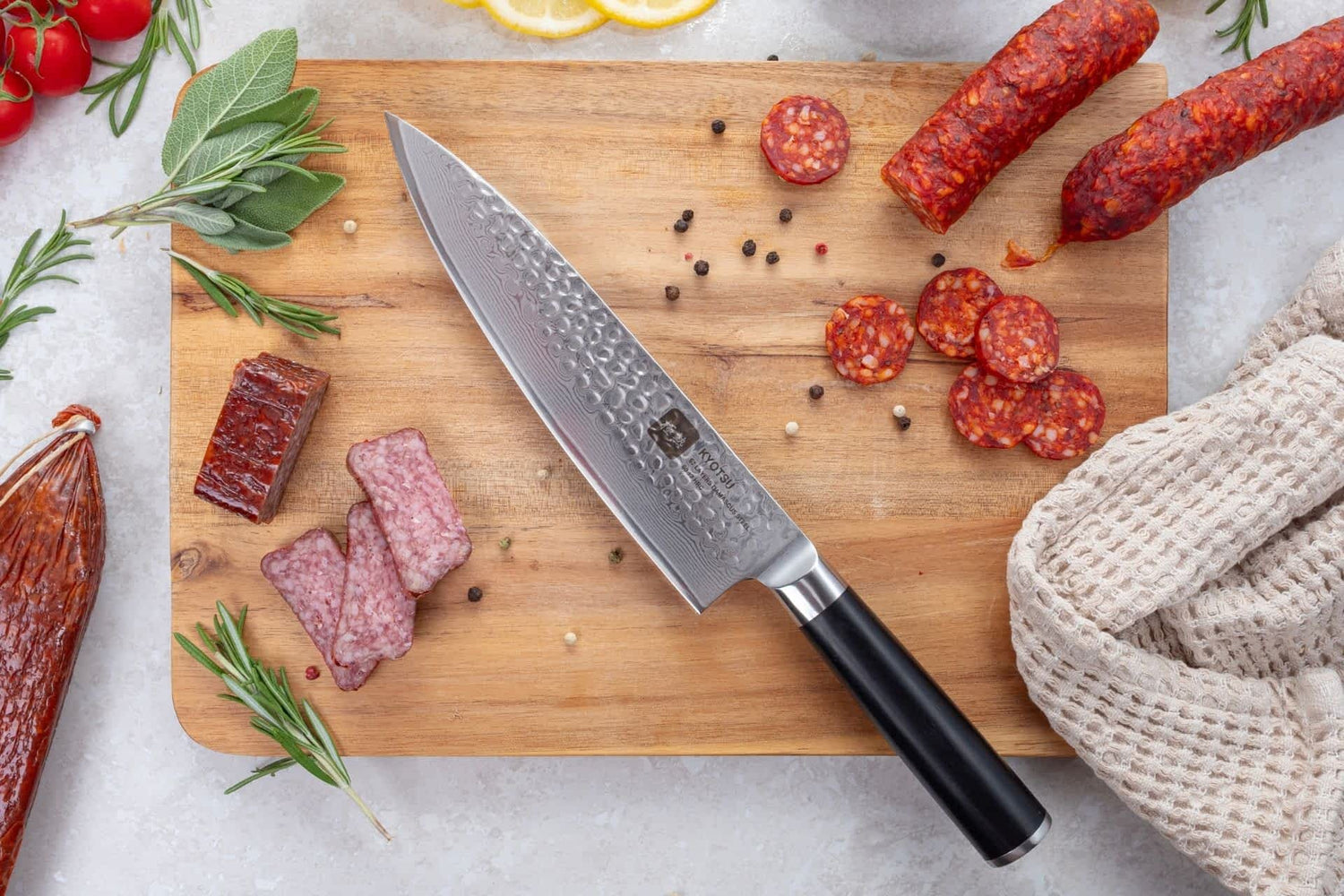 Kyotsu Chefmesser aus Damaststahl auf Holz-Schneidebrett mit frischen Zutaten – stilvolle Produktpräsentation für hochwertige Küchenmesser.