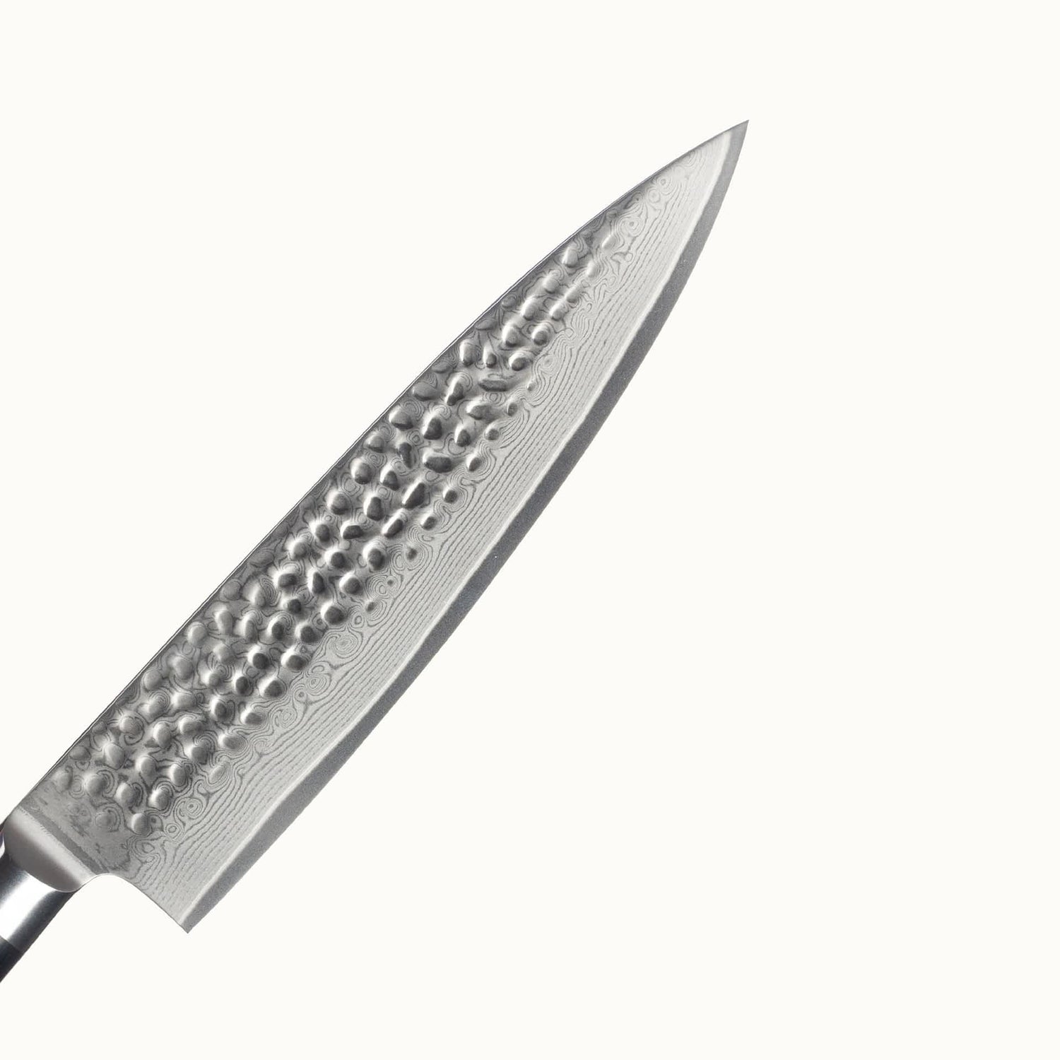Nahaufnahme der Klinge aus Damaststahl mit Hammerschlag. Die wunderschöne Maserung aufgrund der Stahlschichten ist klar erkennbar.
