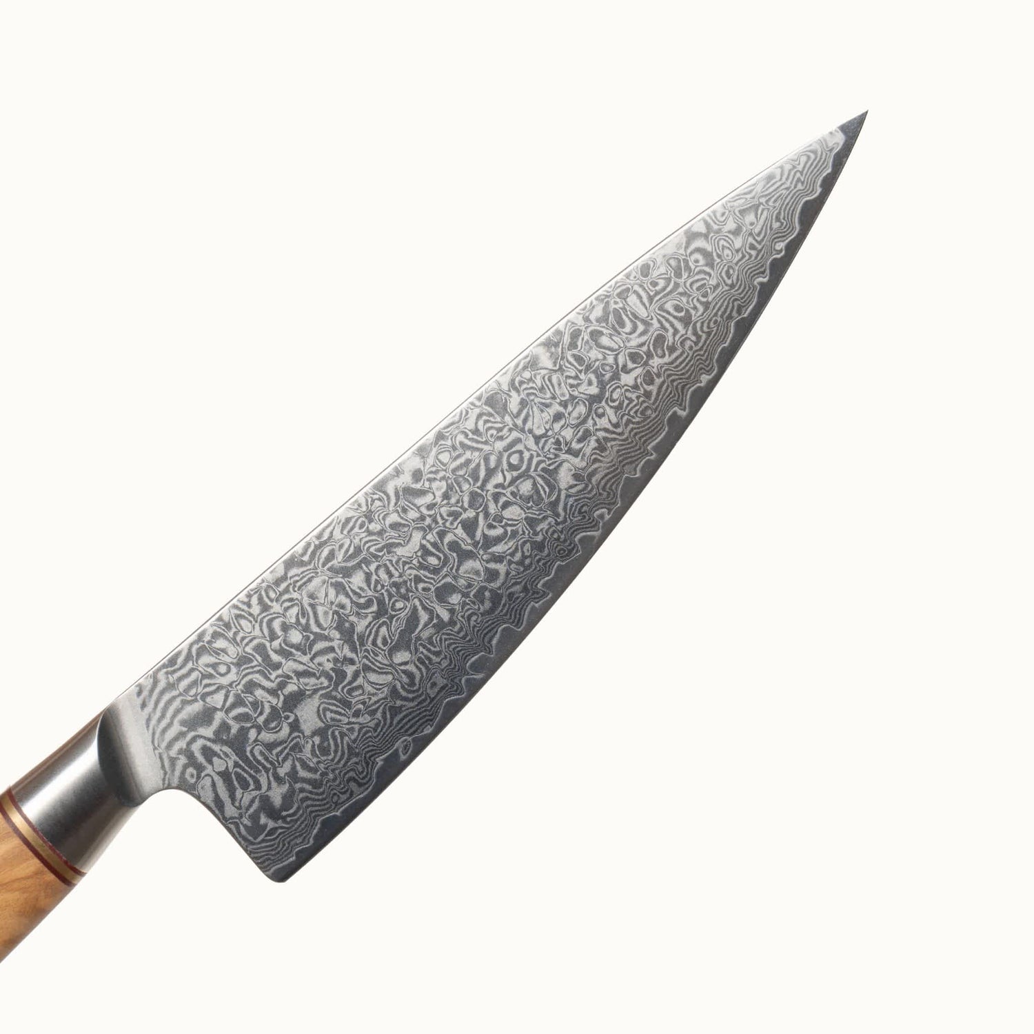 Nahaufnahme der Klinge aus Damaststahl. Die wunderschöne Maserung aufgrund der Stahlschichten ist klar erkennbar.