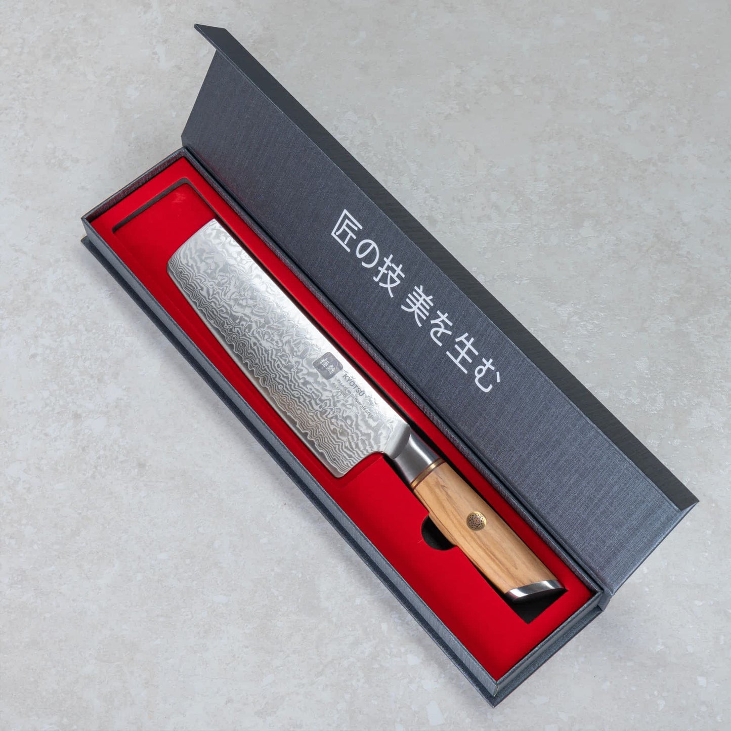 Kyotsu Nakiri-Messer aus Damaststahl in geöffneter Verpackung.