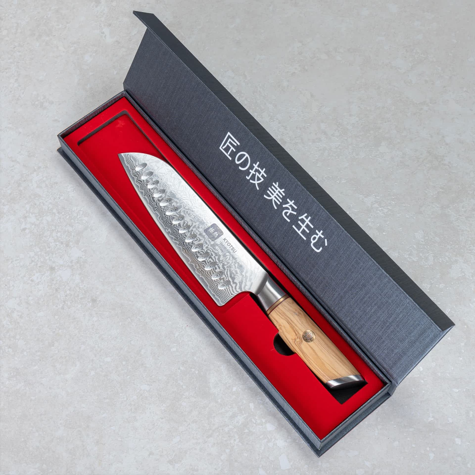 Kyotsu Santoku-Messer aus Damaststahl in geöffneter Verpackung.