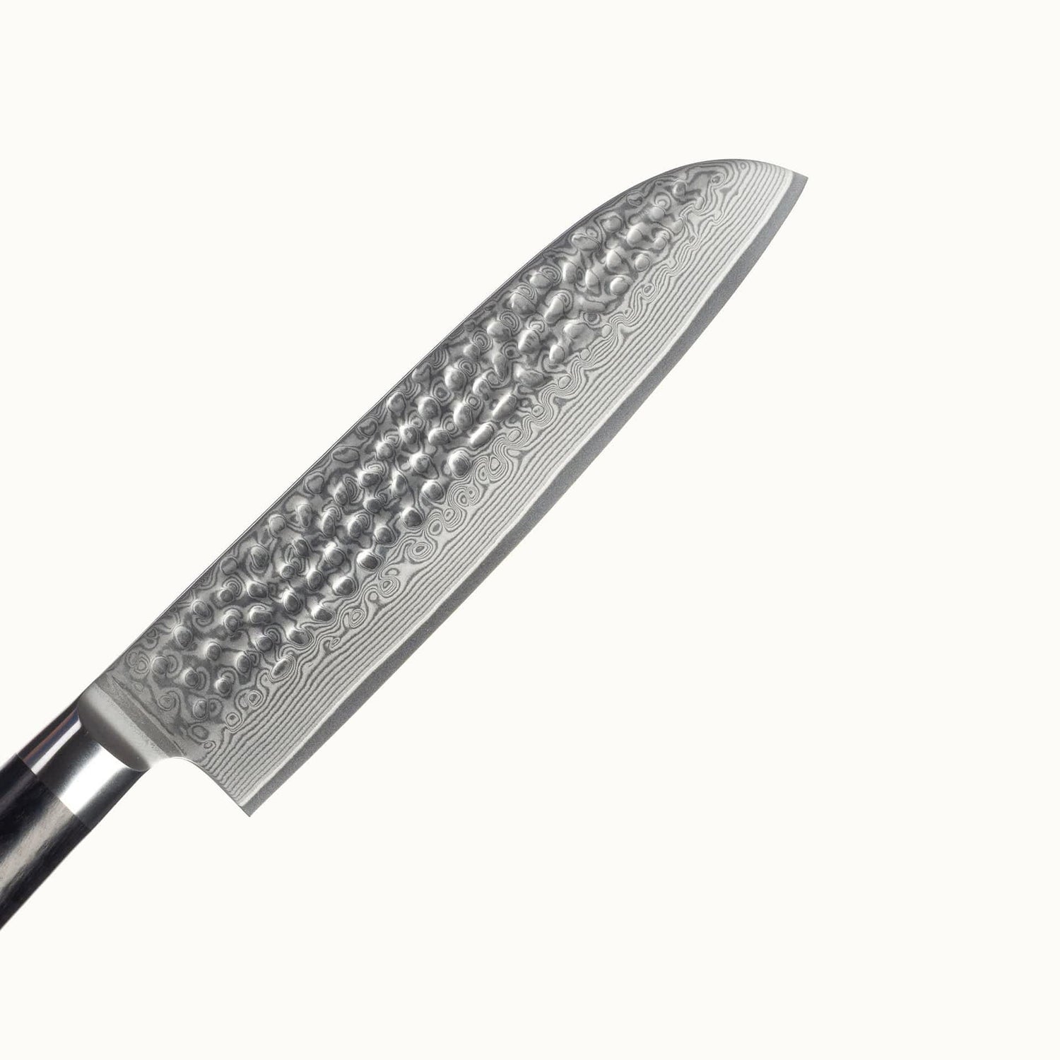 Nahaufnahme der Klinge aus Damaststahl mit Hammerschlag. Die wunderschöne Maserung aufgrund der Stahlschichten ist klar erkennbar.