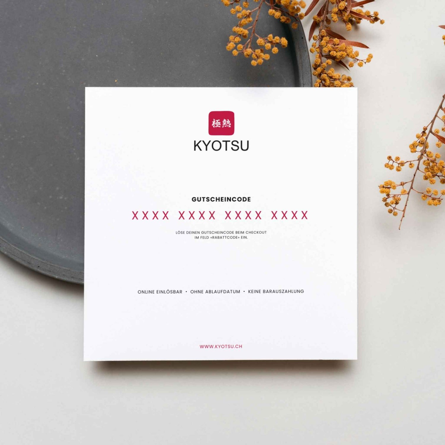 Präsentation der Rückseite des Geschenkgutscheines von Kyotsu auf einem Teller.