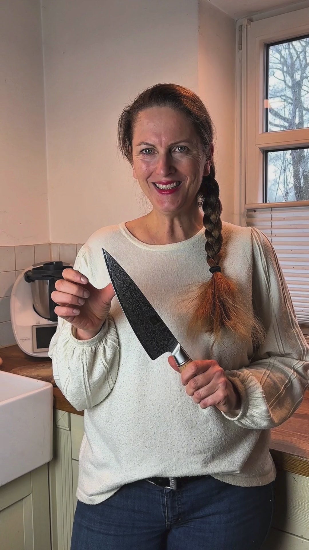 Video-Rückmeldung einer zufriedenen Kundin, die das Chefmesser vorstellt.