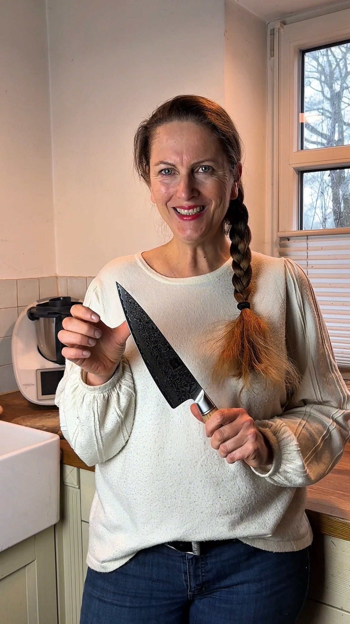 Video-Rückmeldung einer zufriedenen Kundin, die das Chefmesser vorstellt.