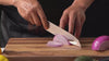 Video eines Koches beim Gebrauch des Kyotsu Santoku-Messer. Er schneidet Gemüse kinderleicht.