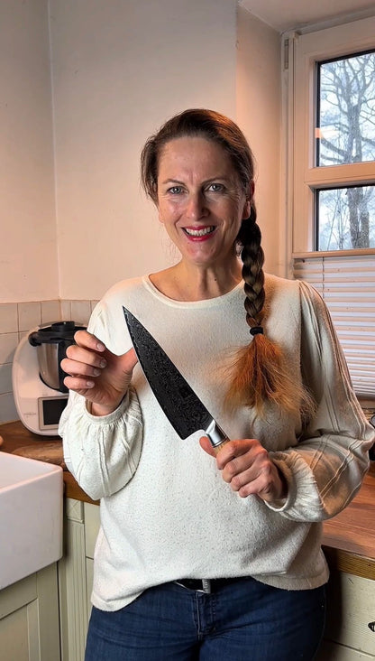 Video-Rückmeldung einer zufriedenen Kundin, die das Chefmesser vorstellt.